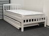 Miki King Single Bed in white, crafted from solid rubberwood, featuring a slatted headboard and footboard with a pull-out trundle for extra sleeping space. Both the main bed and trundle are fitted with comfortable mattresses